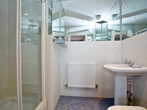 een badkamer met een wastafel en een douche bij Cormorant View in Weymouth