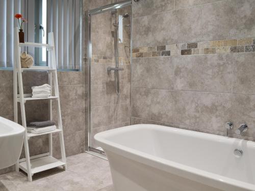 a bathroom with a tub and a shower and a sink at Henry-oscar House in Winchelsea