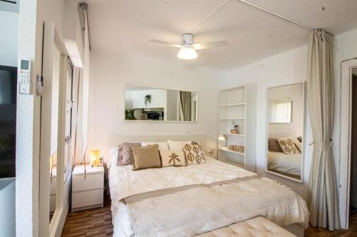 Habitación blanca con cama y espejo en Estudio Lighthouse F 77 en Torrox Costa