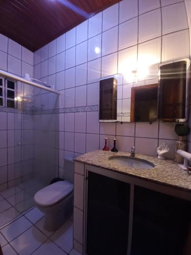 a bathroom with a toilet and a sink and a mirror at CASA COM PISCINA EM ÁREA NOBRE in Boa Vista