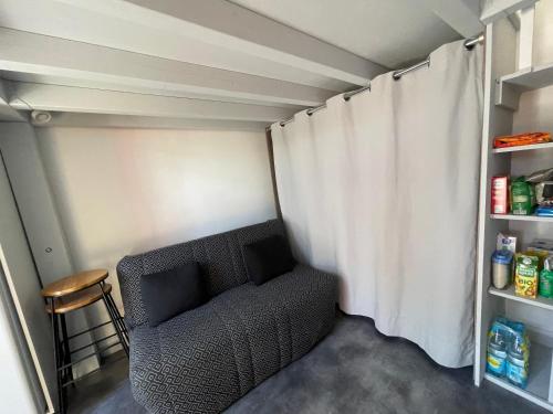 un soggiorno con una sedia e una tenda di Bocage 1 a Mimizan