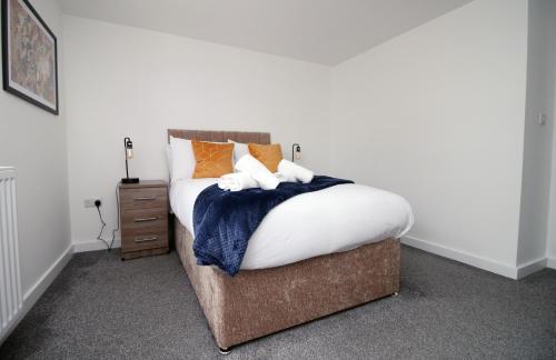 a bed with orange and blue blankets and pillows at Luxury City Loft Apartment! Great Location in Cardiff