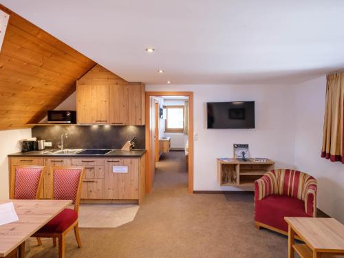 a kitchen with wooden cabinets and a table and chairs at Apart Agnes in Obergurgl