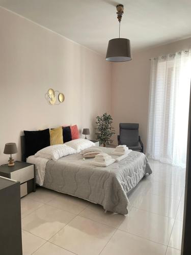 ein weißes Schlafzimmer mit einem großen Bett und einem Stuhl in der Unterkunft La dimora degli Avi in Matera