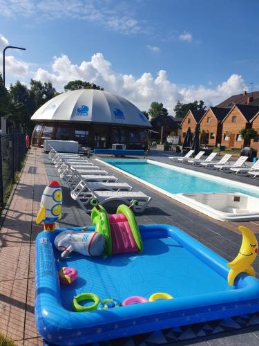 a swimming pool with several lounge chairs and a swimming pool at Tekila Ustronie Morskie in Ustronie Morskie