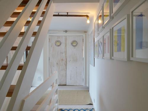a hallway with a wooden door in a house at Seacliff Cottage in Strete