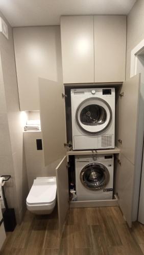 a bathroom with a washing machine and a toilet at Apartamenty Września III in Września