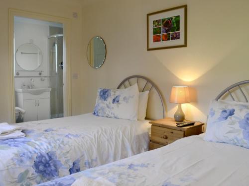um quarto com 2 camas e uma casa de banho com um espelho. em The Gatehouse em Sewerby