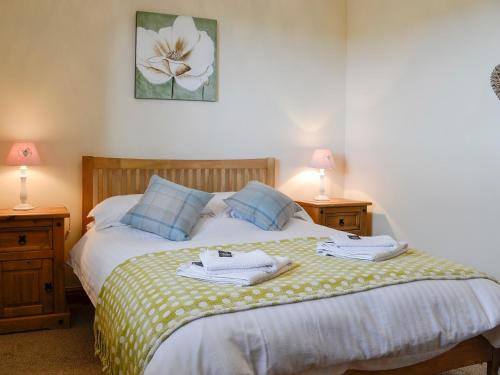 a bedroom with a bed with two towels on it at The Barn in Talsarnau