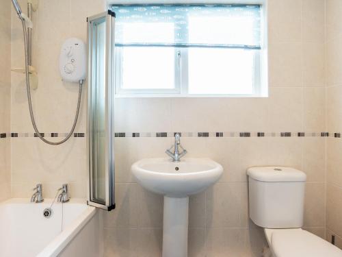 uma casa de banho com um lavatório, um WC e uma janela. em 9 Dolphin Court em Brixham