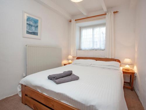 um quarto com uma cama branca com duas toalhas em Smithy em Saint Martin
