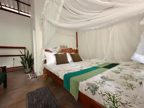 a bedroom with a bed with a canopy at Midigama Inn in Ahangama