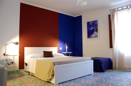 カステッランマーレ・デル・ゴルフォにあるCasa Heliosの青い壁のベッドルーム1室(ベッド1台付)