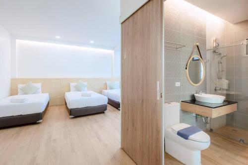 baño con 2 camas, lavabo y espejo en Poollay StayA1 PoolVilla@pattaya พัทยา, en Ban Huai Yai