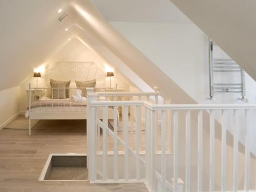 a white staircase with a bed in a room at Gumburnville in Lanteglos