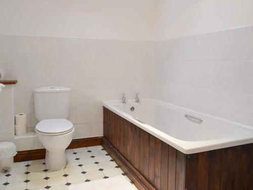 a bathroom with a tub and a toilet and a sink at The Old Byre - 24970 in Frosterley