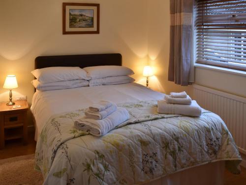 a bedroom with a bed with towels on it at Stable Cottage in South Kilvington