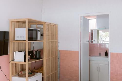 ein Badezimmer mit einem Regal mit einer Mikrowelle und einem Waschbecken in der Unterkunft Black Swan Waterfront Motel in Swansea