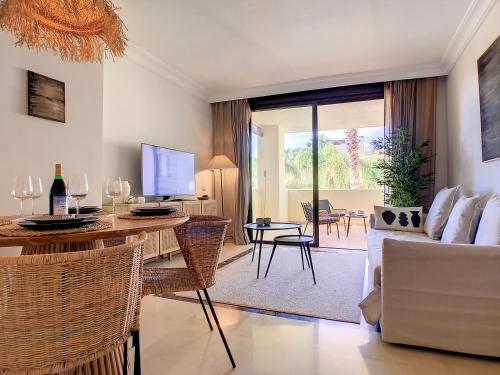 een woonkamer met een tafel en stoelen en een bank bij Roda Golf Resort - 8809 in San Javier