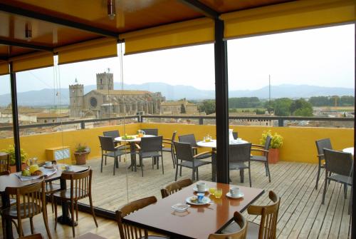 a restaurant with tables and chairs on a balcony at Hotel Canet in Castelló d'Empúries