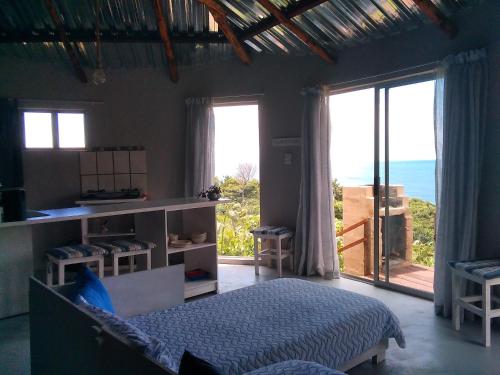 a bedroom with a bed and a view of the ocean at Wildview Self Catering Cottages Coffee Bay, Breakfast & Wi-Fi inc in Coffee Bay