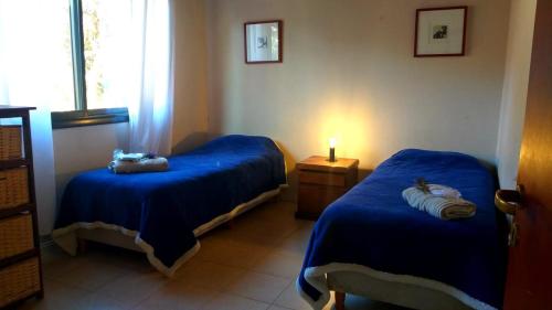 um quarto com duas camas azuis e uma janela em Aldea de Montaña ,La Pichuca em Carpintería