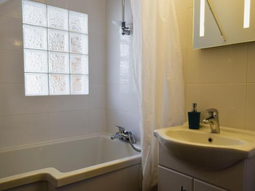 een badkamer met een wastafel, een bad en een douchegordijn bij Millers Rest in Willingham