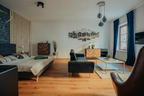 a bedroom with a bed and a living room at Apartmány J&J in Šumperk