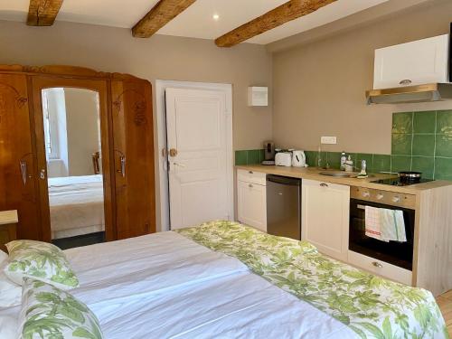 a small kitchen with a bed in a room at Hostellerie Alsacienne in Masevaux