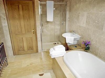 a bathroom with a tub and a toilet and a sink at Willow Cottage in Hadston