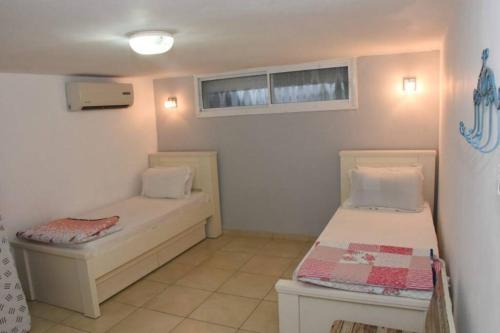 ein kleines Zimmer mit 2 Betten und einem Fenster in der Unterkunft Sounds Suite for families in Migdal