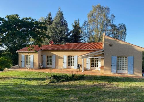 una pequeña casa blanca con un patio de césped en Foix Villa 150m2 dans très grand parc arboré en Foix