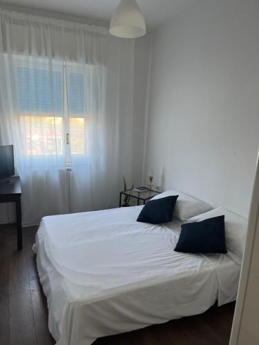 ein Schlafzimmer mit einem weißen Bett mit zwei blauen Kissen in der Unterkunft "StayEasy" Apartment in Sant'Agnello
