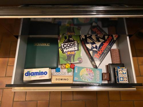 a shelf with a bunch of games and books at Foix Villa 150m2 dans très grand parc arboré in Foix