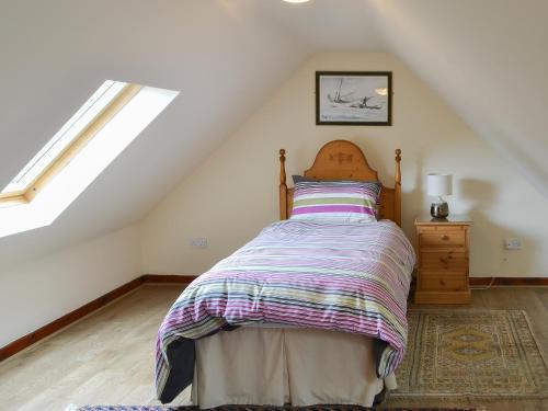 a bedroom with a bed in a attic at Piglet Cottage in Elsdon