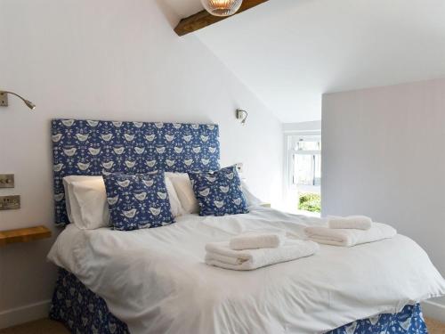 a bedroom with a blue and white bed with towels on it at Esk Cottage in Egton