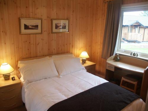 1 dormitorio con 1 cama con ventana y lavamanos en Amber Nook en Tirril