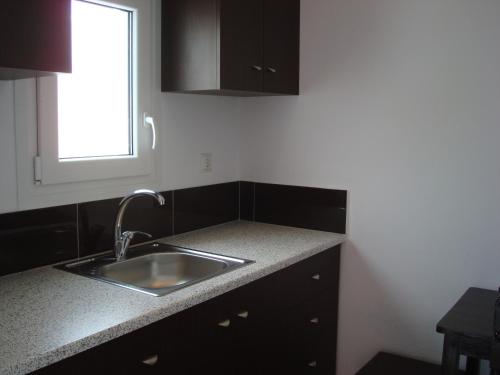 a kitchen with a sink and a window at Elena Studios & Suites in Ornos