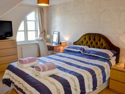 sypialnia z dużym łóżkiem z niebiesko-białymi paskami w obiekcie 12 Maritime House w mieście West Bay