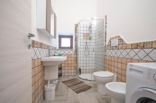 een badkamer met een wastafel, een toilet en een bad bij Sa Matta de s'Oria in Giba