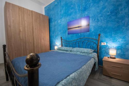 een blauwe slaapkamer met een bed en een blauwe muur bij Sa Matta de s'Oria in Giba