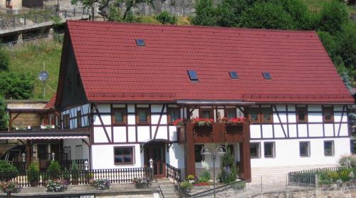 a white and red house with a red roof at Ferienwohnung Gisela Winkler in Rathen
