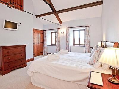 a bedroom with a large white bed and a desk at Kestrel Barn - Cul in Sculthorpe