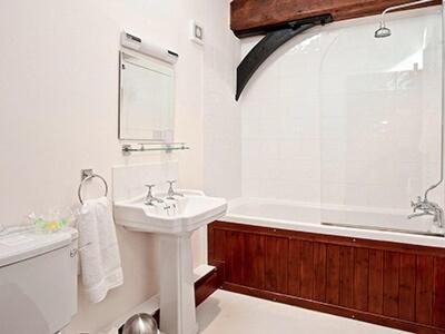 a white bathroom with a sink and a bath tub at Kestrel Barn - Cul in Sculthorpe