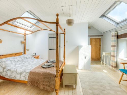 a bedroom with a bed with a wooden frame at Town End Barn in Warslow