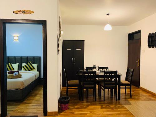 een eetkamer met een tafel en een bed bij City Apartment’s Nuwara Eliya in Nuwara Eliya