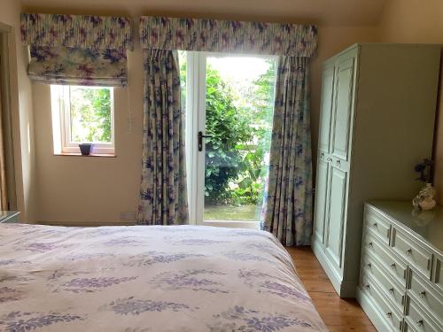 um quarto com uma cama e uma grande janela em Wisteria Cottage em Skirpenbeck