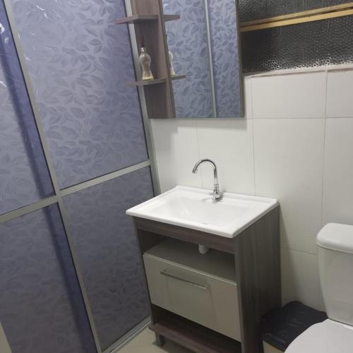 La salle de bains est pourvue d'un lavabo et d'une douche. dans l'établissement Hospedagem Almirante, à São Francisco de Paula