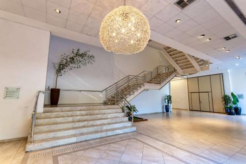 un gran vestíbulo con escaleras y una lámpara de araña en Wyndham Garden São Paulo Convention Nortel, en São Paulo