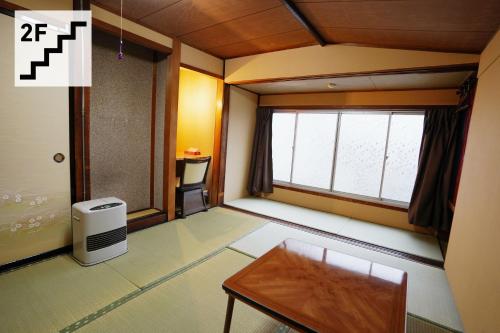 a small room with a table and a window at Hostel Murasaki Ryokan in Takayama
